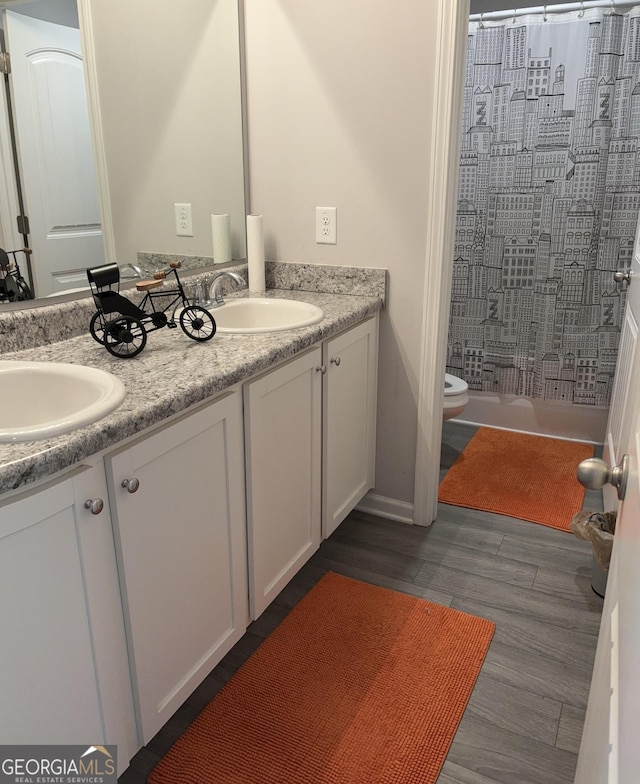 457 Panhandle Pl, Hampton, GA 30228 - bathroom with a shower with curtain, toilet, double vanity, and wood finished floors