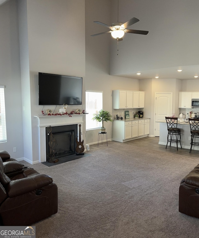 457 Panhandle Pl, Hampton, GA 30228 - living room featuring a towering ceiling, carpet flooring, a ceiling fan, recessed lighting, and a fireplace with flush hearth