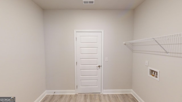 washroom featuring washer hookup, light wood-type flooring, and baseboards
