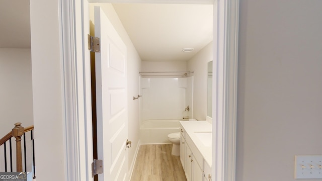 full bathroom featuring wood finished floors, vanity, toilet, and  shower combination