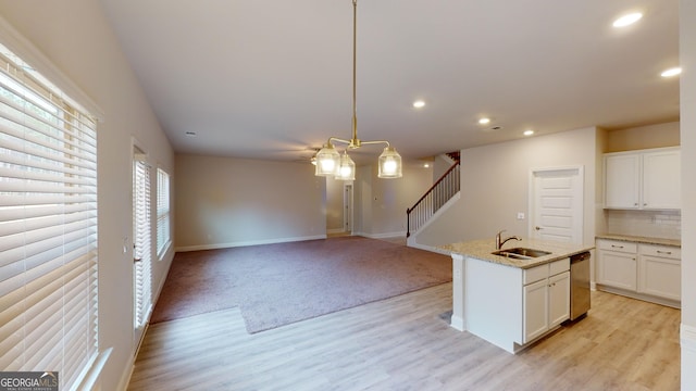 kitchen featuring dishwasher, a sink, light wood-style floors, recessed lighting, and baseboards
