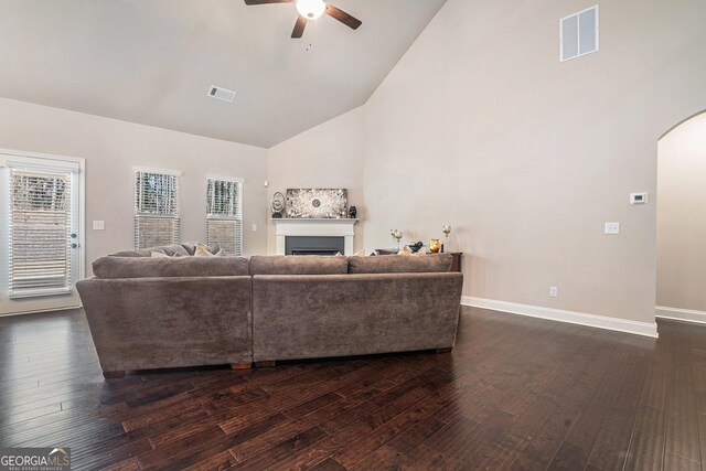 3415 Linstead Ct, Loganville, GA 30052 - living room with arched walkways, ceiling fan, high vaulted ceiling, a fireplace, and dark wood-style floors