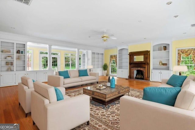 357 Breeze Hill Ln, Canton, GA 30114 - living room featuring ornamental molding, wood finished floors, a ceiling fan, built in shelves, and a brick fireplace