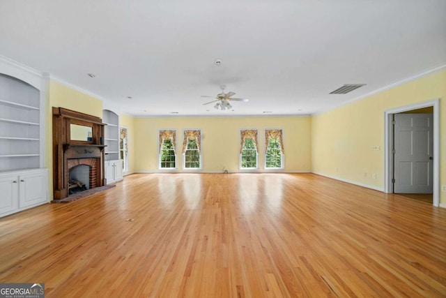 357 Breeze Hill Ln, Canton, GA 30114 - unfurnished living room with a ceiling fan, a fireplace, light wood finished floors, ornamental molding, and built in features