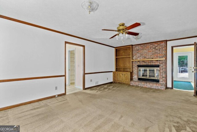 357 Breeze Hill Ln, Canton, GA 30114 - unfurnished living room featuring crown molding, carpet flooring, a ceiling fan, built in shelves, and a brick fireplace