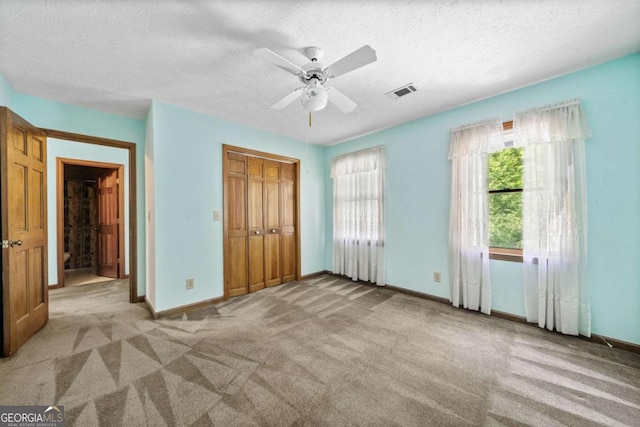 357 Breeze Hill Ln, Canton, GA 30114 - unfurnished bedroom with carpet, a closet, a textured ceiling, and a ceiling fan