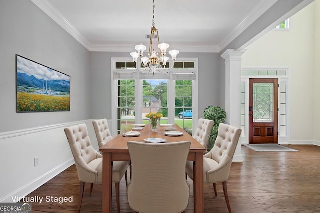 dining room featuring a chandelier, wood finished floors, crown molding, baseboards, and decorative columns