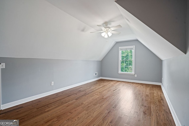 additional living space featuring wood finished floors, a ceiling fan, vaulted ceiling, and baseboards