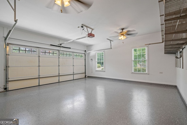 garage featuring ceiling fan, a garage door opener, and baseboards