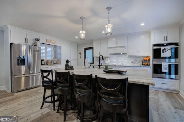 118 Arrowhead Dr, Cartersville, GA 30120 - kitchen with stainless steel appliances, a sink, white cabinets, light wood-style flooring, and tasteful backsplash