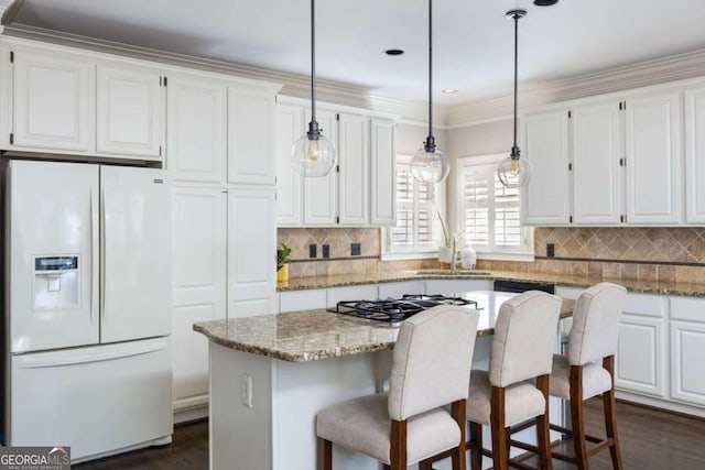 kitchen with white fridge with ice dispenser, a sink, white cabinetry, a kitchen island, and decorative backsplash
