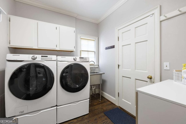 laundry area featuring cabinet space, independent washer and dryer, ornamental molding, dark wood-type flooring, and baseboards