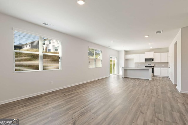 5221 Mulberry Crk Lot 44, Flowery Branch, GA 30542 - unfurnished living room with light wood-type flooring, baseboards, and recessed lighting