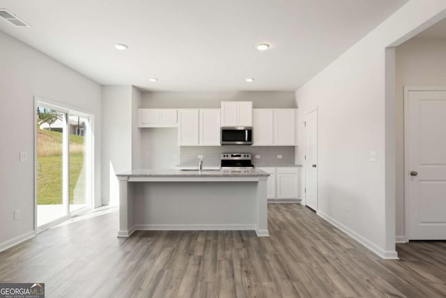 5221 Mulberry Crk Lot 44, Flowery Branch, GA 30542 - kitchen with appliances with stainless steel finishes, wood finished floors, white cabinets, backsplash, and baseboards