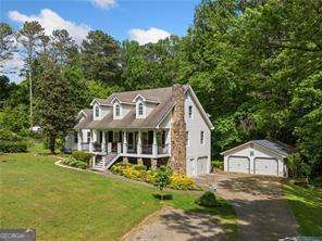 1822 Morgan Rd, Canton, GA 30115 - cape cod home with a porch, a front yard, an outdoor structure, a garage, and driveway