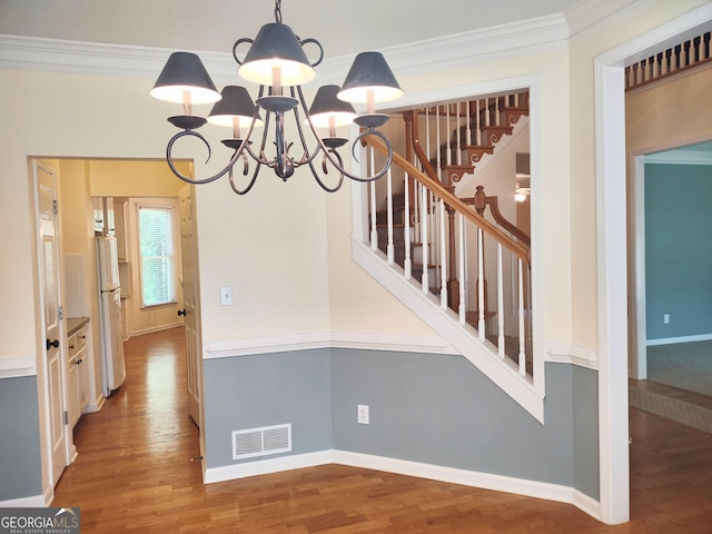 308 Bell Isle, Mcdonough, GA 30252 - hallway featuring wood finished floors, a chandelier, stairway, ornamental molding, and baseboards