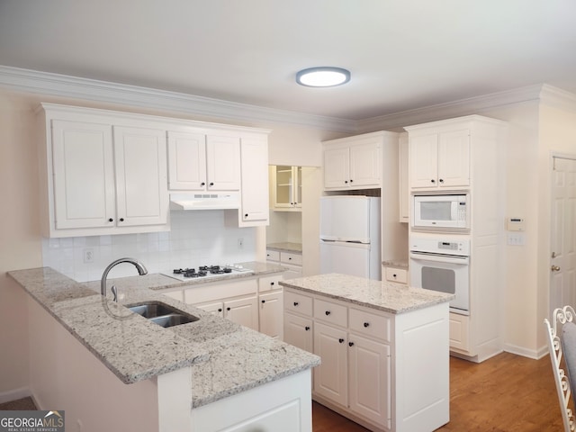 308 Bell Isle, Mcdonough, GA 30252 - kitchen featuring white appliances, under cabinet range hood, a peninsula, a sink, and white cabinets