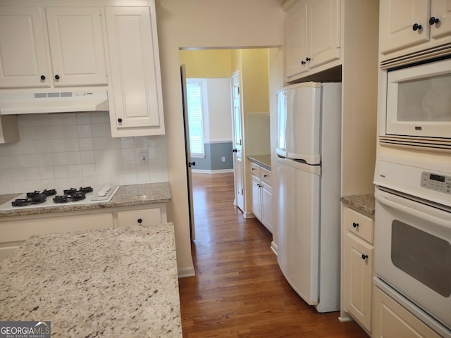 308 Bell Isle, Mcdonough, GA 30252 - kitchen featuring white appliances, under cabinet range hood, dark wood-style flooring, white cabinetry, and decorative backsplash