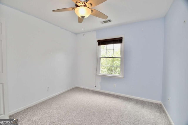 carpeted empty room featuring ceiling fan and baseboards