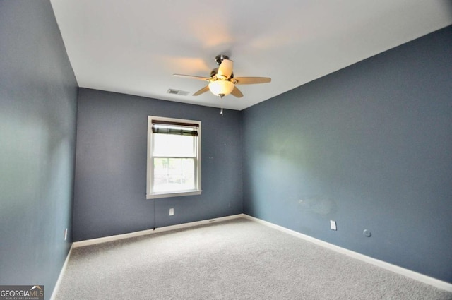 spare room with ceiling fan, carpet, and baseboards