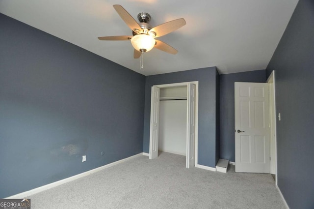 unfurnished bedroom featuring carpet flooring, baseboards, a closet, and a ceiling fan