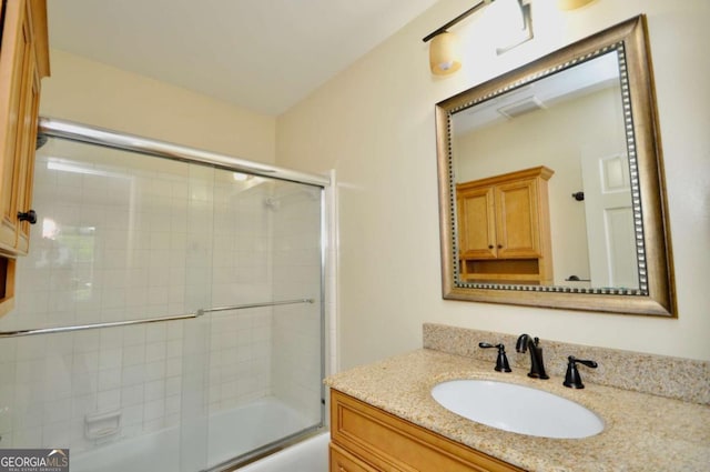 bathroom featuring vanity and shower / bath combination with glass door