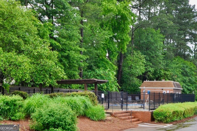surrounding community with fence and a swimming pool