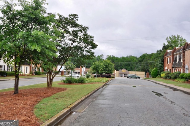 view of asphalt road featuring curbs
