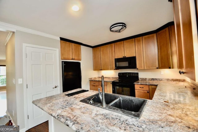 kitchen with black appliances, a sink, a peninsula, crown molding, and brown cabinets