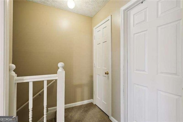 373 Dixie Ct, Lawrenceville, GA 30046 - corridor with an upstairs landing, a textured ceiling, baseboards, and carpet floors
