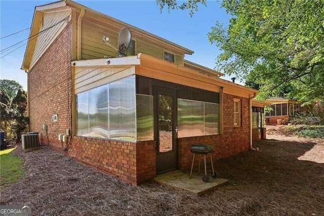 373 Dixie Ct, Lawrenceville, GA 30046 - view of side of property featuring a sunroom, central air condition unit, and brick siding
