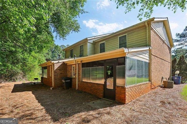 373 Dixie Ct, Lawrenceville, GA 30046 - back of property with brick siding, a sunroom, and central air condition unit