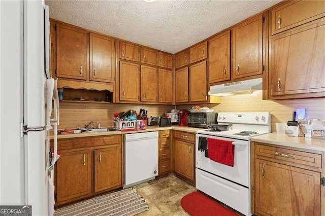 373 Dixie Ct, Lawrenceville, GA 30046 - kitchen featuring white appliances, under cabinet range hood, brown cabinetry, light countertops, and a sink