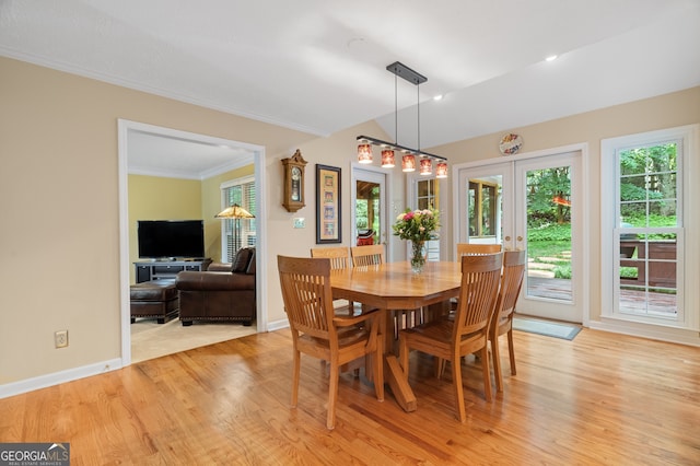 dining room featuring light wood-style floors, crown molding, french doors, and baseboards