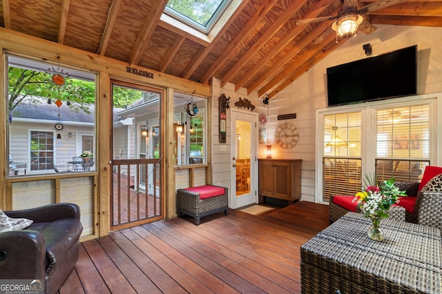 sunroom / solarium with lofted ceiling, plenty of natural light, and a skylight