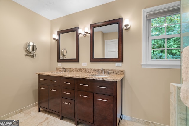 bathroom featuring baseboards and double vanity