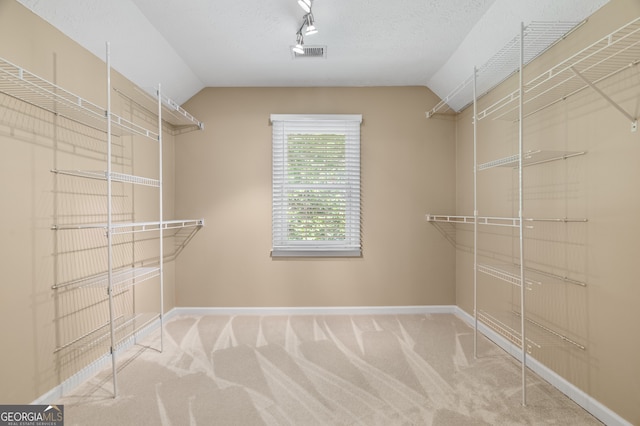 walk in closet featuring carpet and lofted ceiling