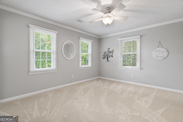 unfurnished room with ornamental molding, baseboards, light carpet, a ceiling fan, and a textured ceiling