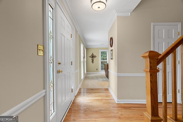 hall with crown molding, light wood-style flooring, and baseboards