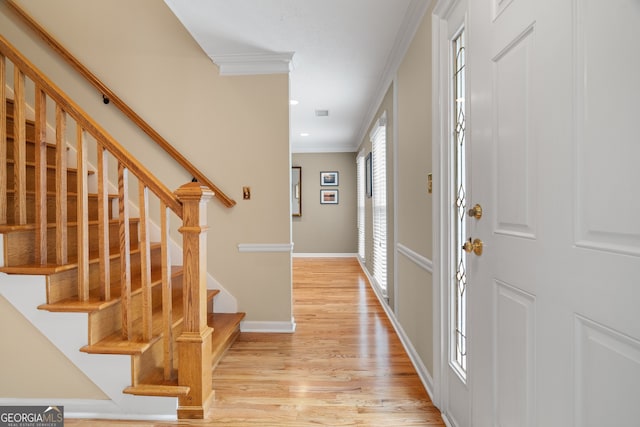 foyer entrance featuring crown molding, light wood-style flooring, baseboards, stairway, and recessed lighting