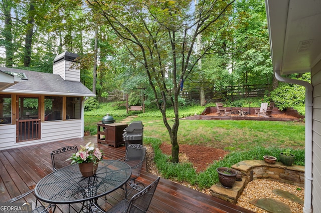 deck with a sunroom, a yard, and outdoor dining space
