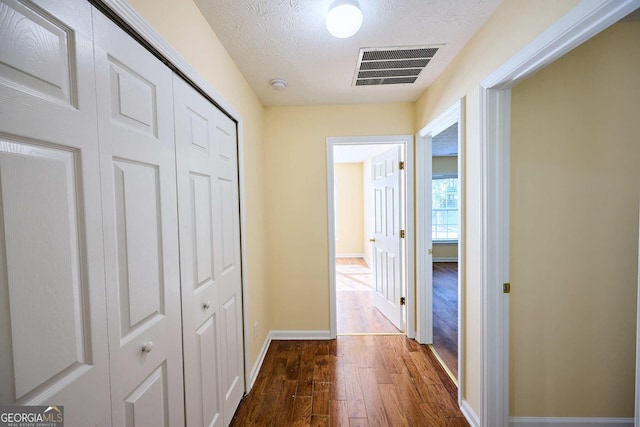 3350 Cooper Woods Dr, Loganville, GA 30052 - hallway with dark wood-style floors, a textured ceiling, and baseboards