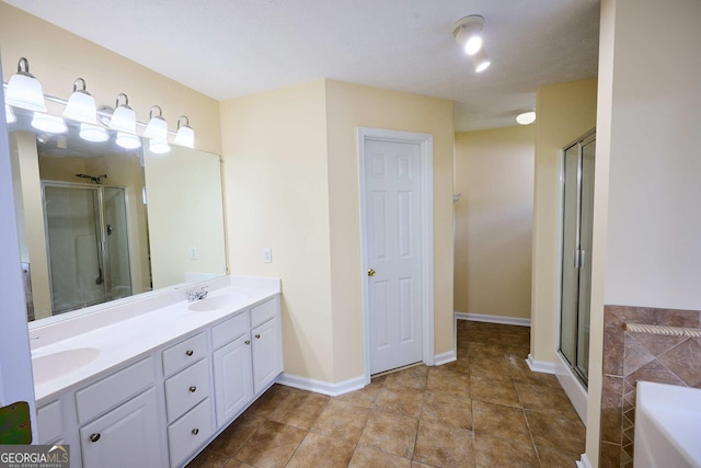 3350 Cooper Woods Dr, Loganville, GA 30052 - bathroom with a shower stall, double vanity, a bath, tile patterned floors, and baseboards