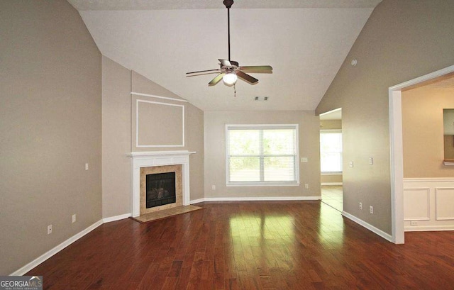 3350 Cooper Woods Dr, Loganville, GA 30052 - unfurnished living room with vaulted ceiling, wood finished floors, a ceiling fan, a tile fireplace, and baseboards