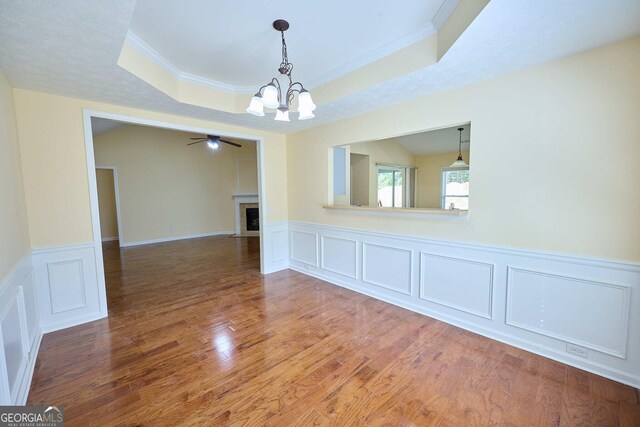 3350 Cooper Woods Dr, Loganville, GA 30052 - unfurnished room featuring a chandelier, a tray ceiling, a decorative wall, wood finished floors, and ornamental molding
