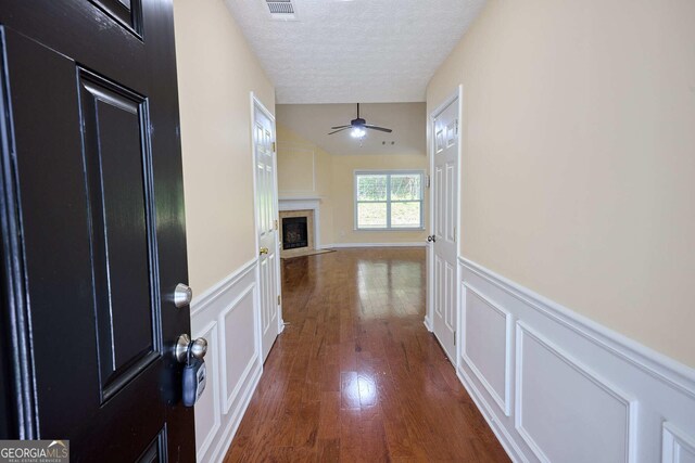 3350 Cooper Woods Dr, Loganville, GA 30052 - hallway with a decorative wall, wood finished floors, a textured ceiling, and wainscoting