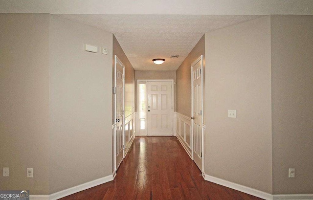 3350 Cooper Woods Dr, Loganville, GA 30052 - hall with dark wood-style floors, a textured ceiling, and baseboards