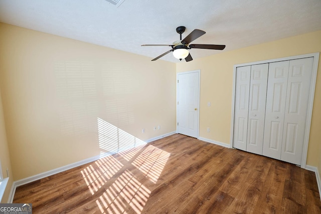 3350 Cooper Woods Dr, Loganville, GA 30052 - unfurnished bedroom with wood finished floors, baseboards, a closet, and a ceiling fan