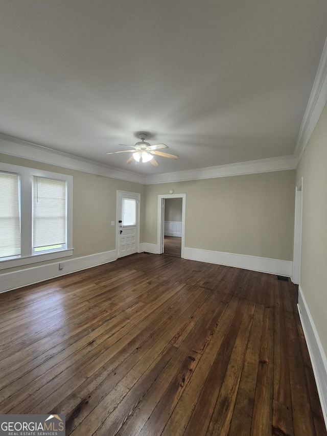 empty room with dark wood-type flooring, ceiling fan, ornamental molding, and baseboards