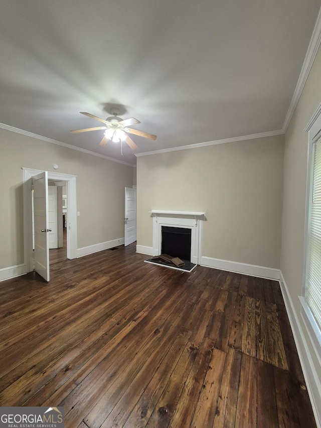 unfurnished living room with dark wood finished floors, a ceiling fan, a fireplace with raised hearth, ornamental molding, and baseboards
